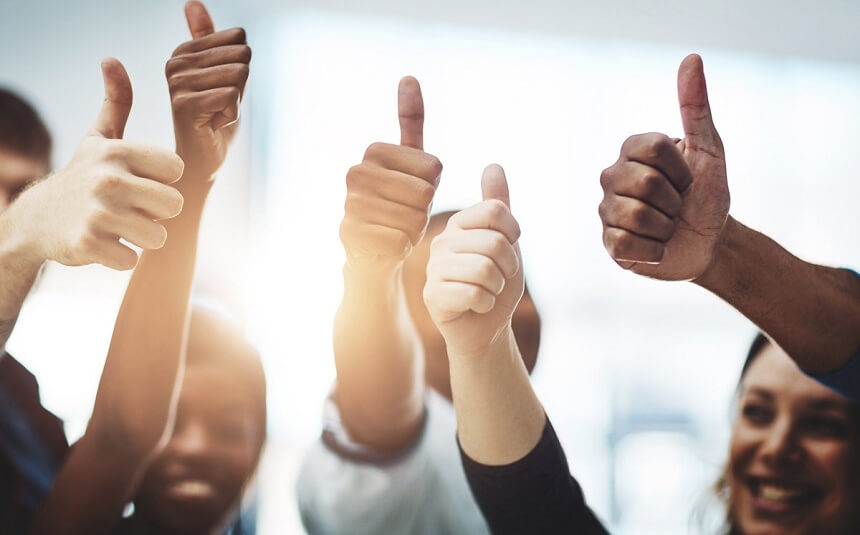 Pessoas em uma palestra de motivação fazendo positivo com a mão