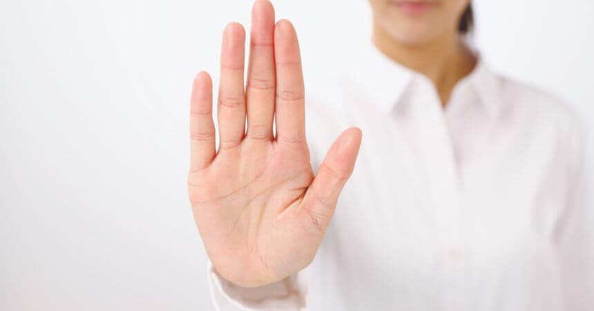 Mão de mulher mostrando como combater o assédio sexual no ambiente corporativo