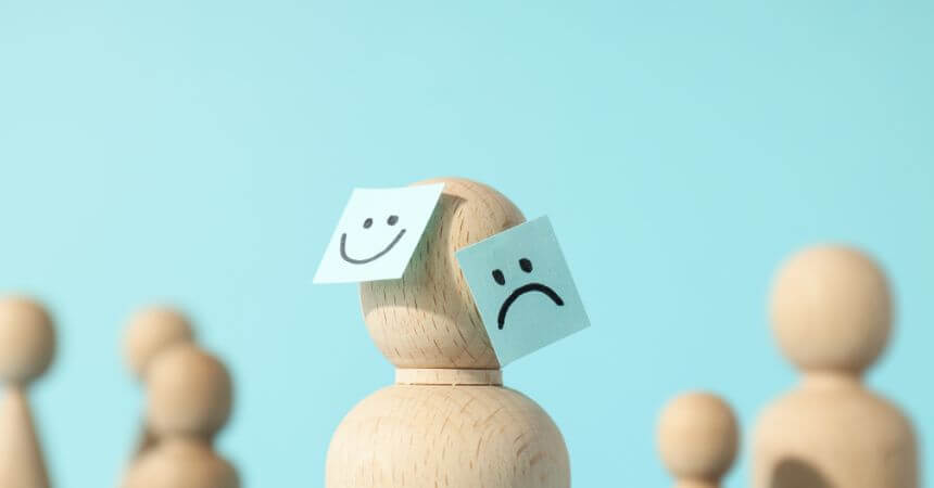 Boneco triste e feliz representando como criar um ambiente de trabalho que promova a saúde mental